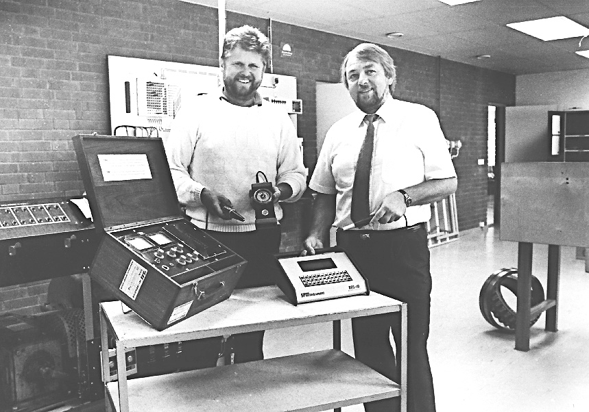 Two SPM representatives showing measuring instruments from SPM in the early days