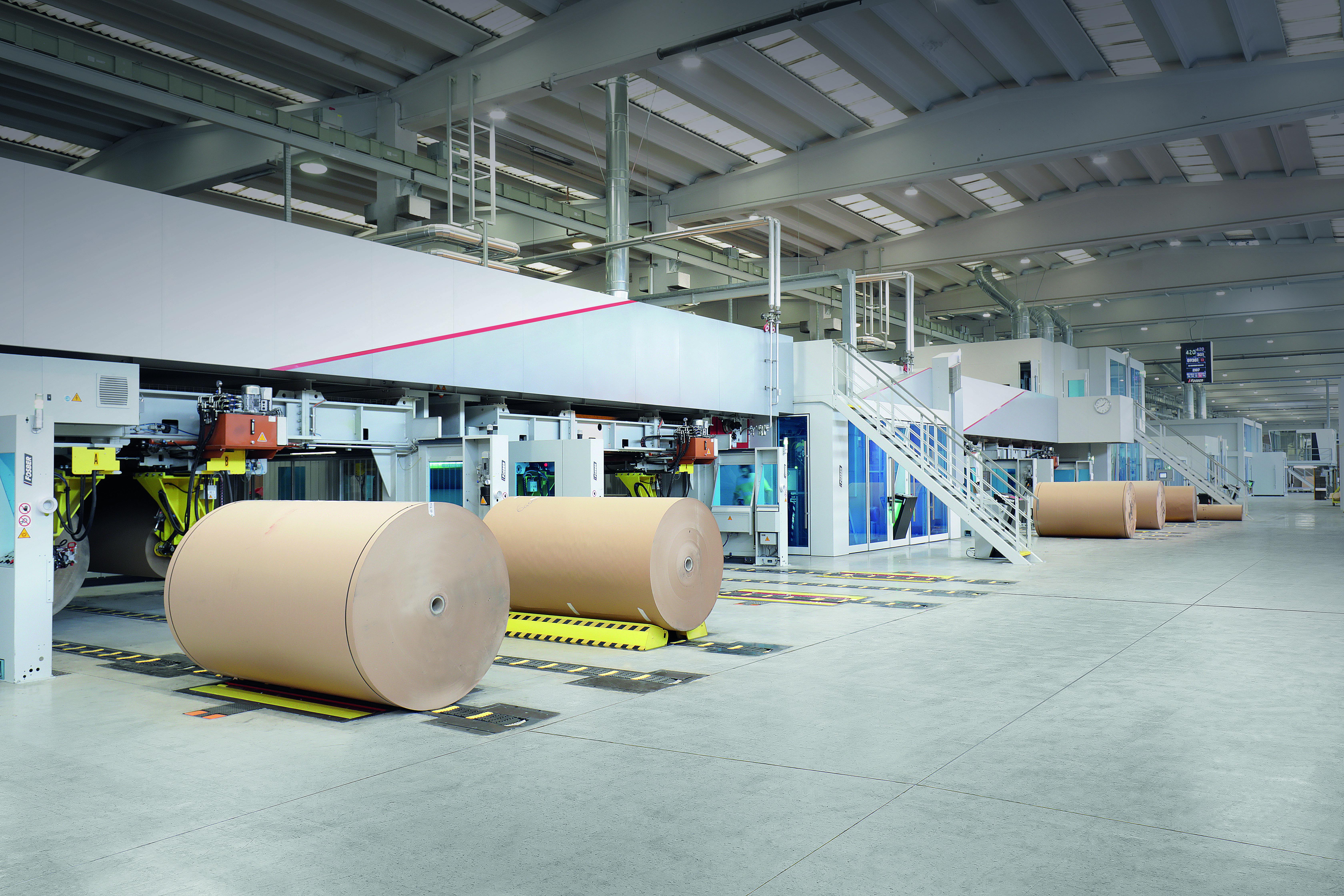 Large corrugated board rolls in a clean, industrial environment