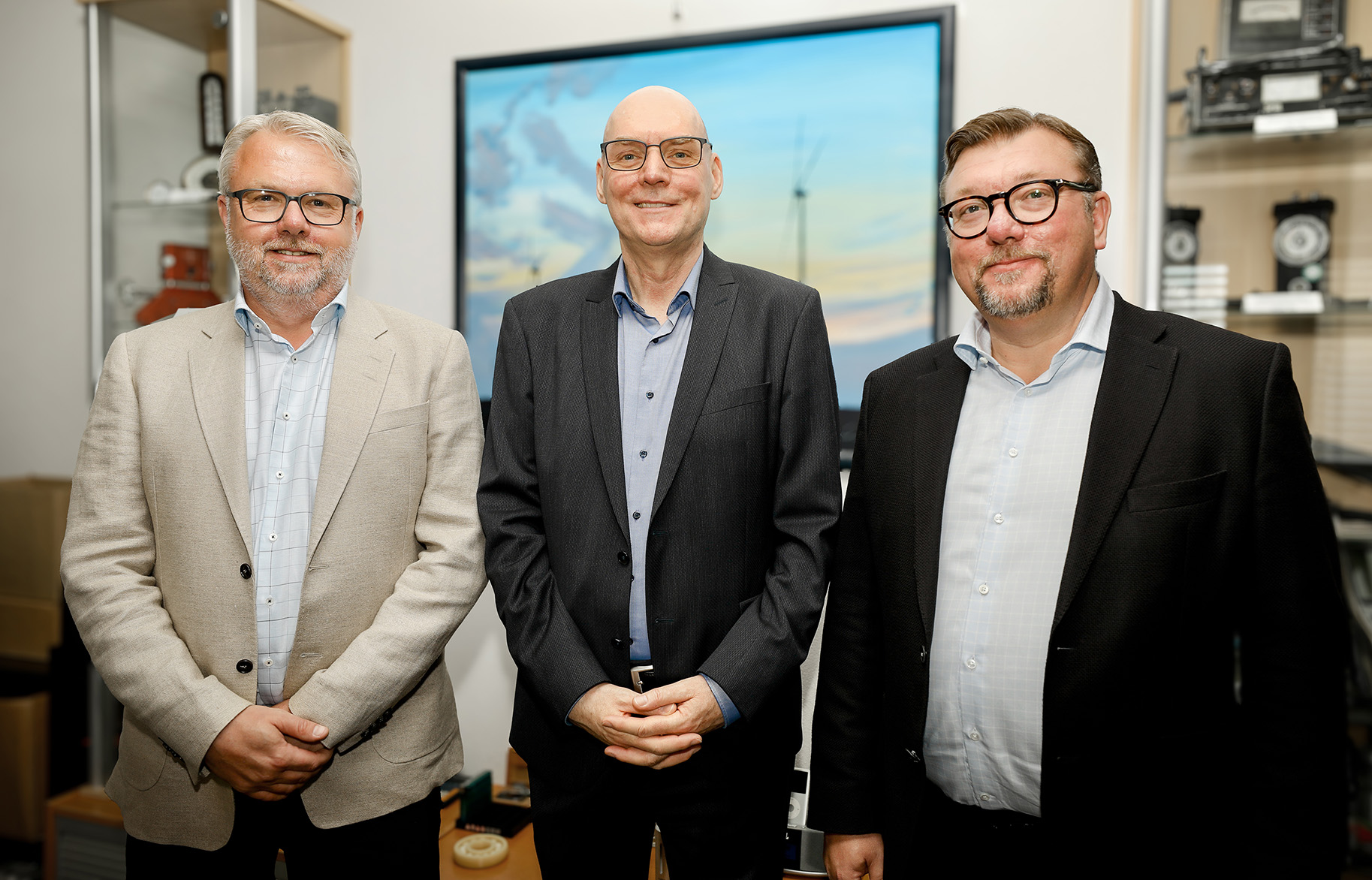 Three smiling people in an office environment